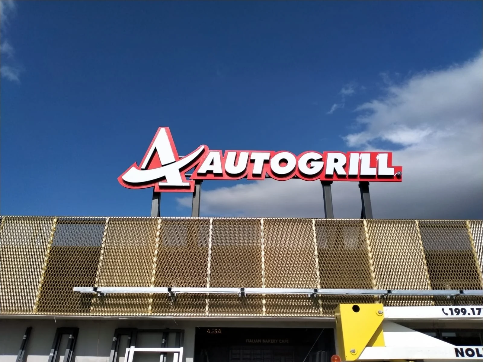 Insegna Autogrill Montepulciano sulla sommità dell’edificio, con una piattaforma visibile in basso.