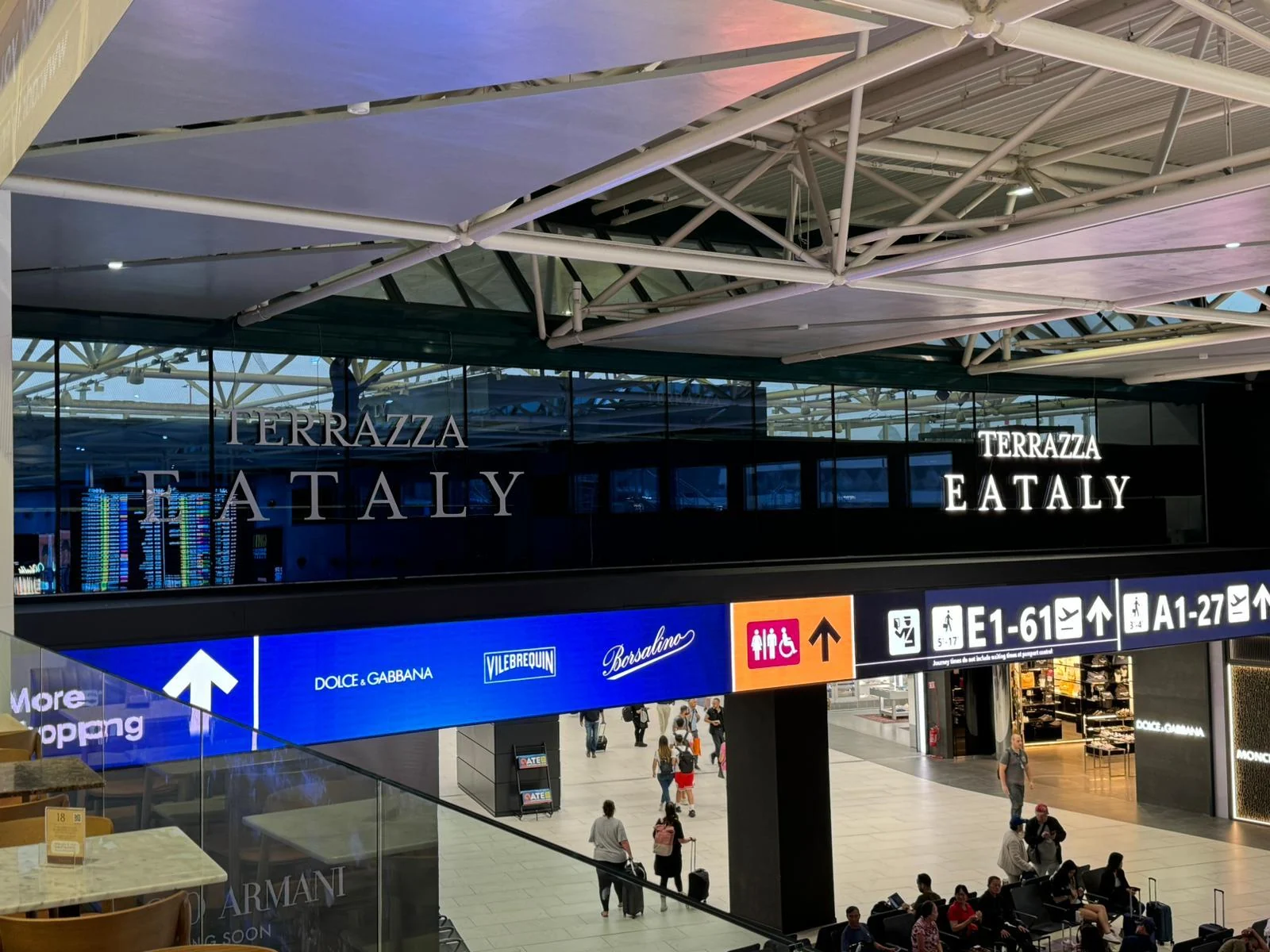 Vista rialzata delle insegne Terrazza Eataly applicate sulla vetrata dell’aeroporto di Fiumicino.